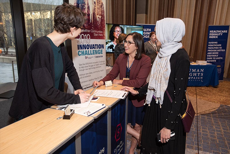 People at a booth for AHA's Accelerating Health Equity Conference